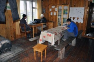 Infrastructure of the ‘big house’ looks cozy on the picture, but the wind is blowing through the walls and window frames, the stove is not strong enough to heat up the sleeping rooms and chairs definitely arrived at the end of their life cycle (Photo: G. Schaepman-Strub, July 2013).